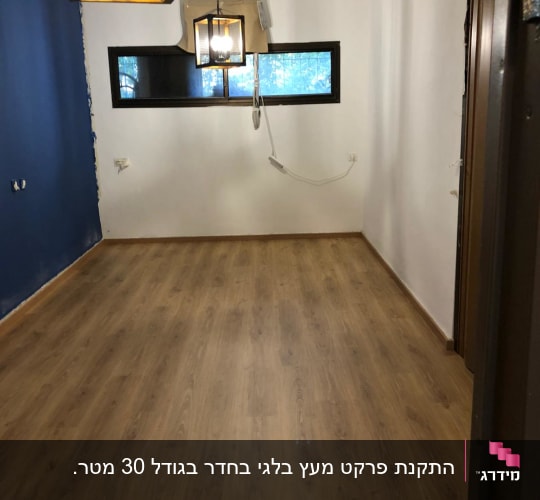 רצפת פרקט עץ בחדר עם קירות לבנים